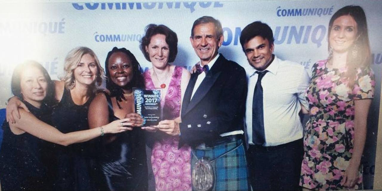 Aakash Andrews and fellow attendees holding an award