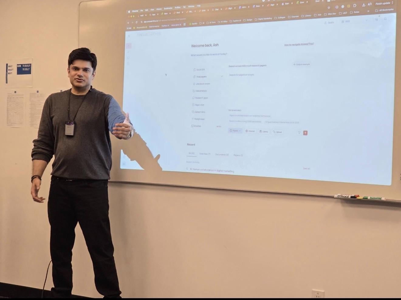 Aakash Andrews giving instruction beside a projected digital learning interface